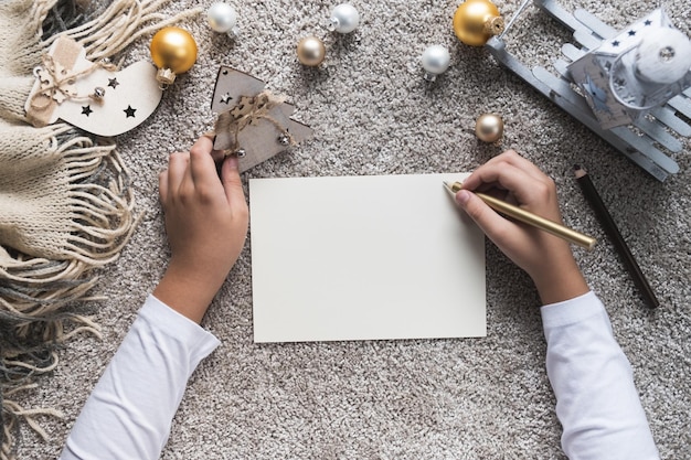 Photo child hands writes letter on blank sheet of paper christmas and new year concept