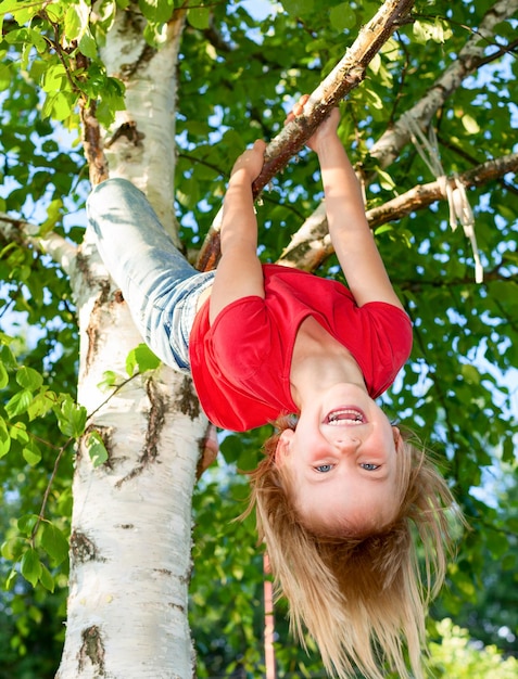 Child hanging from a tree branch