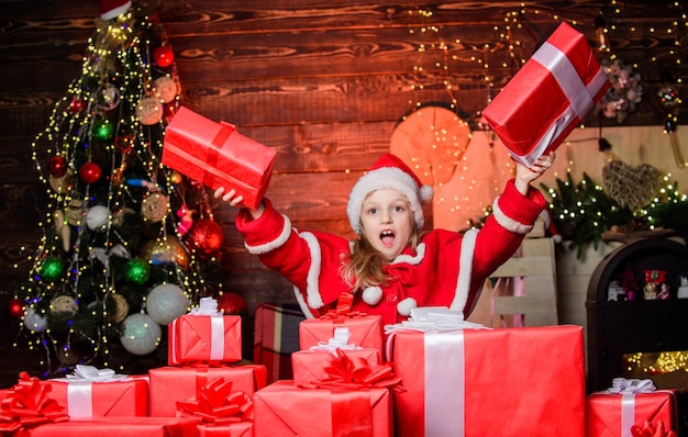 Child happy excited girl find gifts near christmas tree merry
christmas happy childhood concept kid wear santa hat hold wrapped
christmas gift box santa brought me gifts happiness and joy