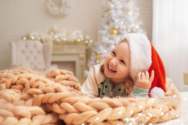 Child in a hat on a blanket of natural sheep wool