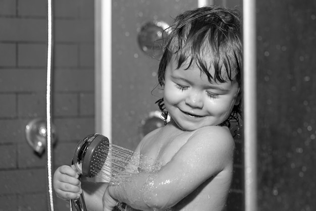 Child having fun to bath happy baby taking a bath playing with foam bubbles infant washing and bathi