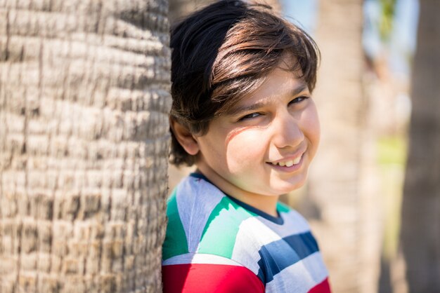 Child having fun on summer trip in beach palm park