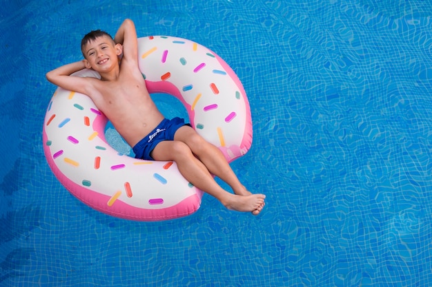 Foto bambino che si diverte con galleggiante a bordo piscina