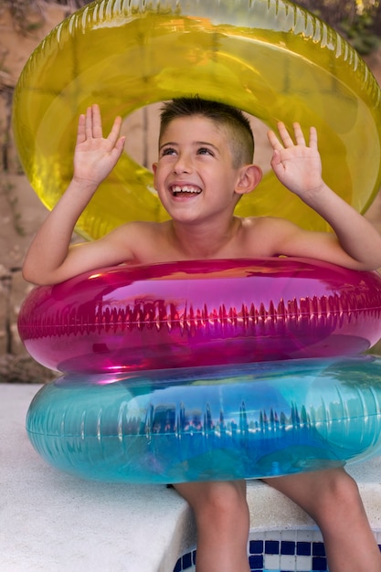 Foto bambino che si diverte con galleggiante a bordo piscina