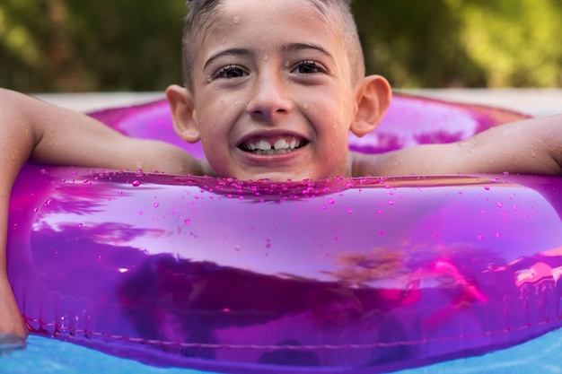 Фото Ребенок развлекается с поплавком у бассейна