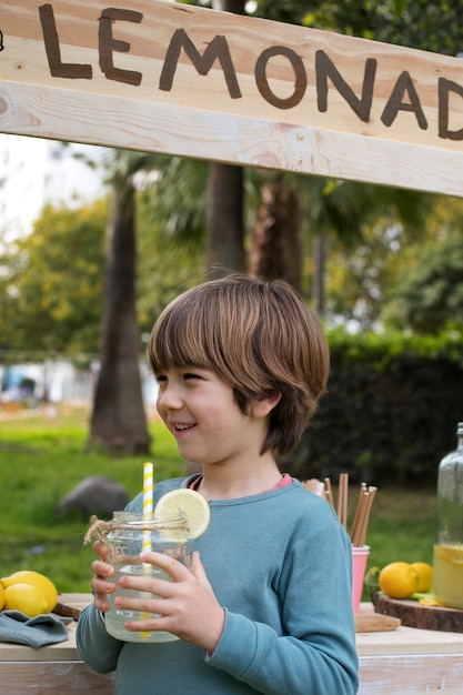 Foto bambino che ha un chiosco di limonata