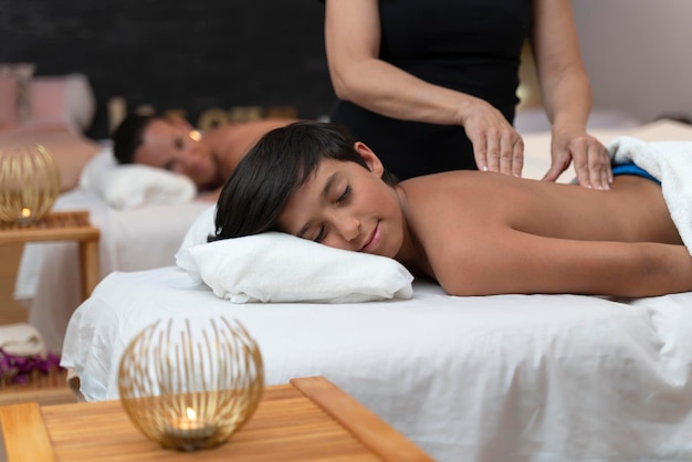 Child having a massage in a spa with his mother