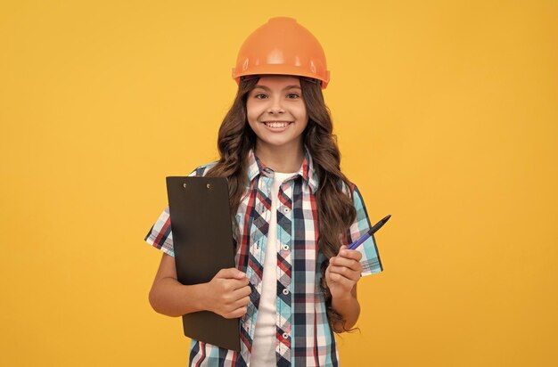 Child in helmet hold project construction documents signing a contract kid education