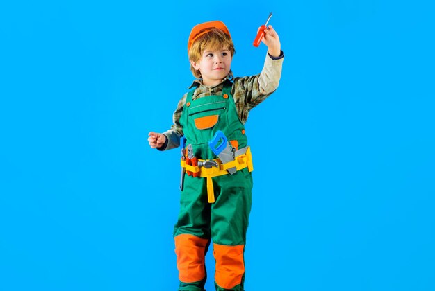 Child in helmet and toolbelt with screwdriver little repairman or craftsman with tools for building