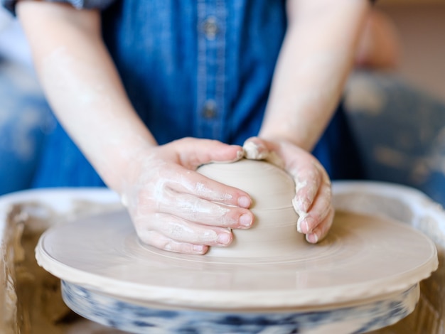 子供の趣味。創造的な陶器の余暇。芸術的な子供の育成。粘土で働く少女