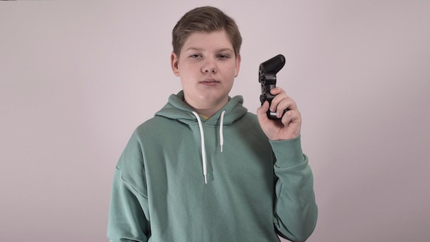 A child hold a gamepad like a gun, a winner in the game, a parody of a shooter