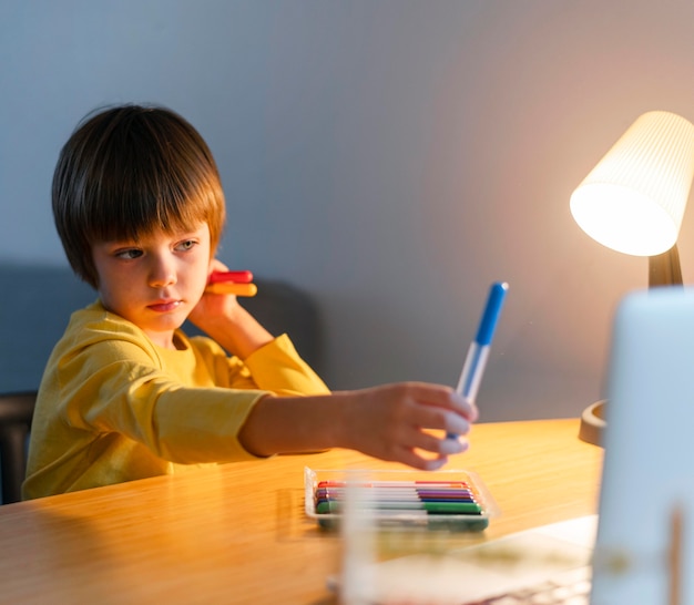 Child holding a blue marker in hand