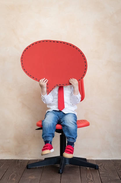 Child holding cardboard speech bubble