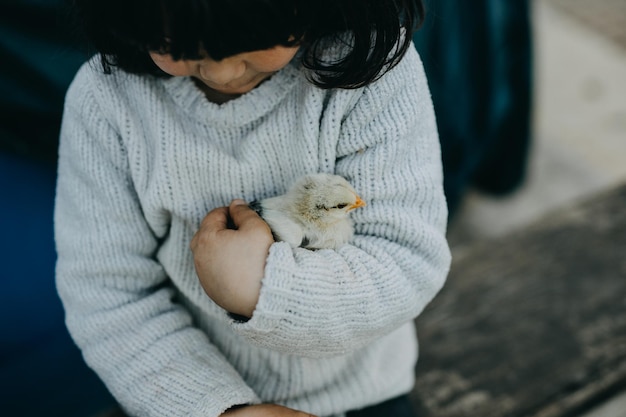 Фото Младенец с цыпленком на руках