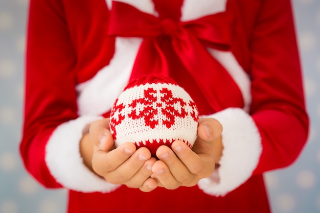 Child holding Christmas ball. Xmas holiday concept