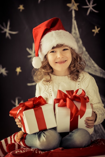 Child holding Christmas gift. Xmas holiday concept