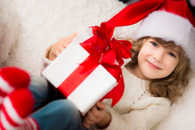 Child holding Christmas gift. Xmas holiday concept