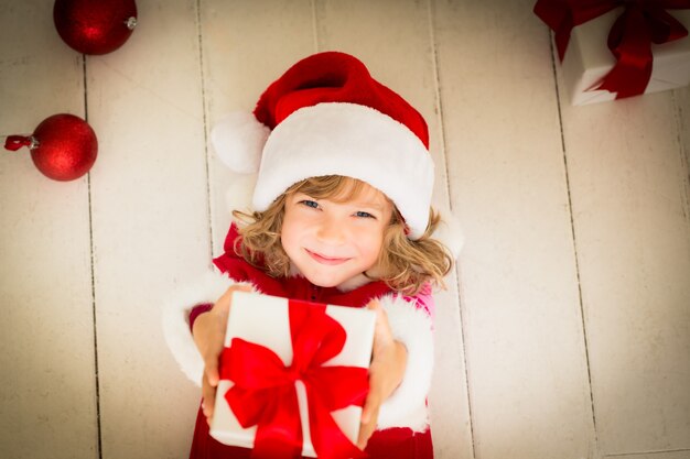 Child holding Christmas gift. Xmas holiday concept