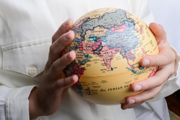 Photo child holding a globe in hand