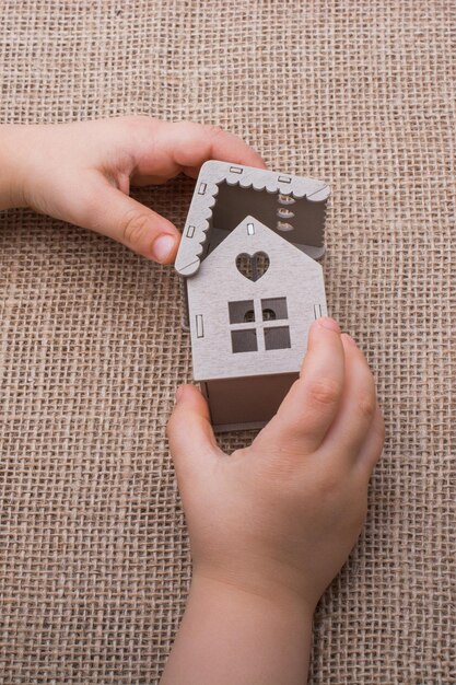 Child holding a model house on a canvas