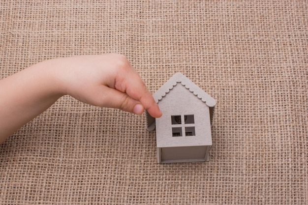 Child holding a model house on a canvas