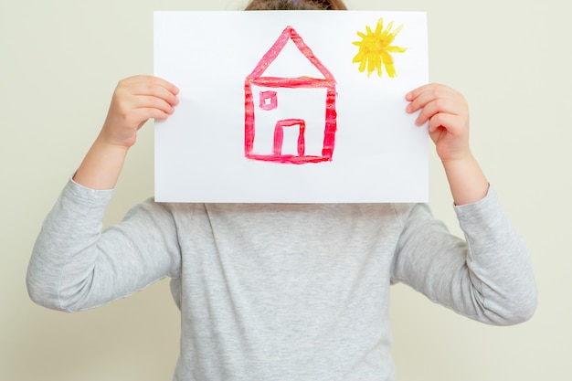 Child holding picture of house