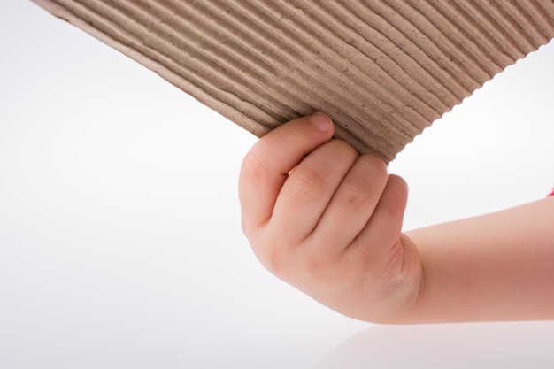 Child holding a piece of brown color cardboard