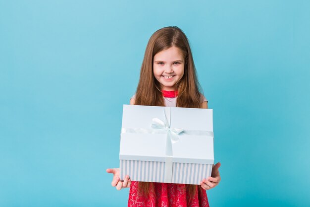 Child holding presents on a blue Christmas time or birthday