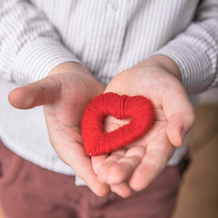 Child holding a small red heart.