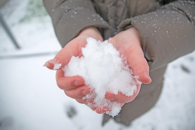 Child holding the snow in the hands Happy in winter