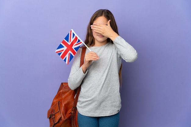 手で目を覆っている孤立した背景の上にイギリスの旗を持っている子供。何かを見たくない