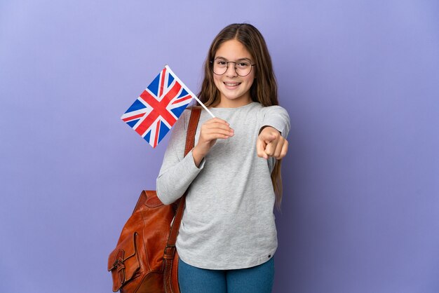 행복한 표정으로 앞을 가리키는 고립된 배경 위에 영국 국기를 들고 있는 아이