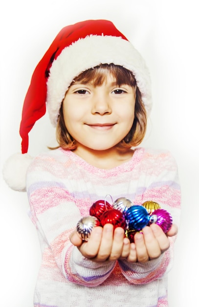 Child holds a Christmas decor and gifts on a white background Selective focus