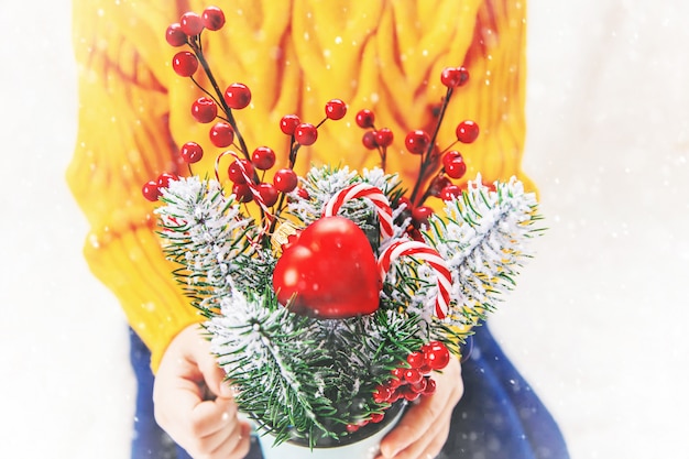 Child holds a Christmas decor and gifts on a white background. Selective focus.