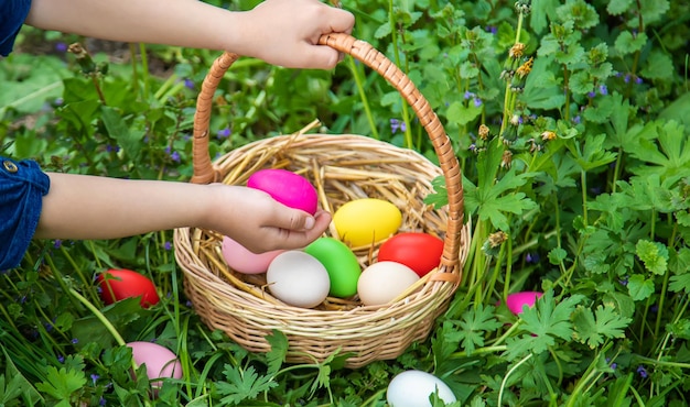 Foto il bambino tiene le uova di pasqua nelle sue mani. messa a fuoco selettiva.