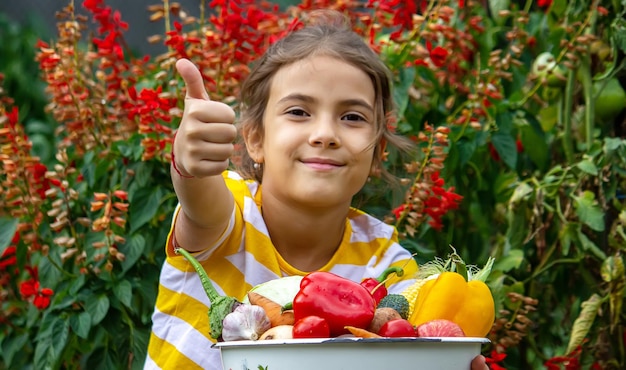 子供は手に野菜の収穫を持っています選択的な焦点