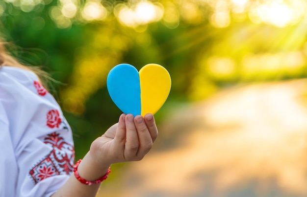 A child holds a heart of the Ukrainian flag Selective focus