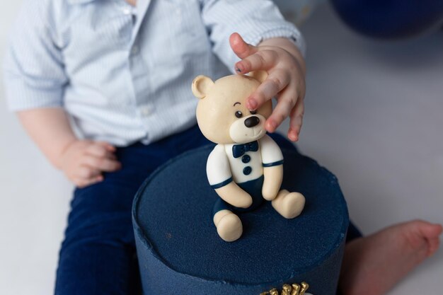 the child holds in his hand a bear with a cake holiday dessert