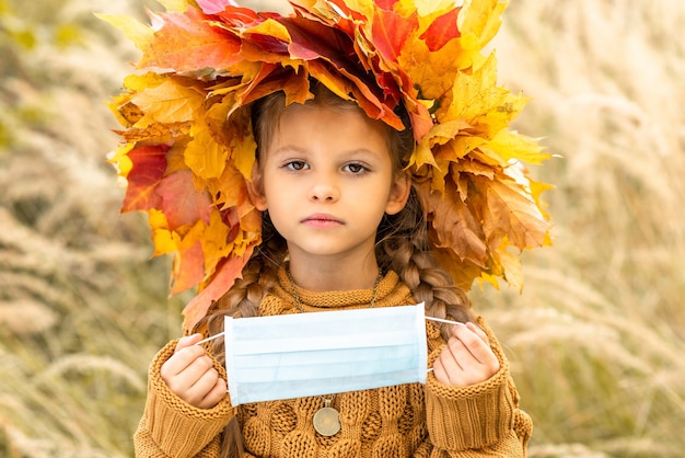 child holds a medical mask against coronavirus.