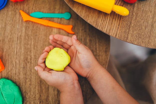 Photo the child holds plasticine in his hands modeling workshop concept