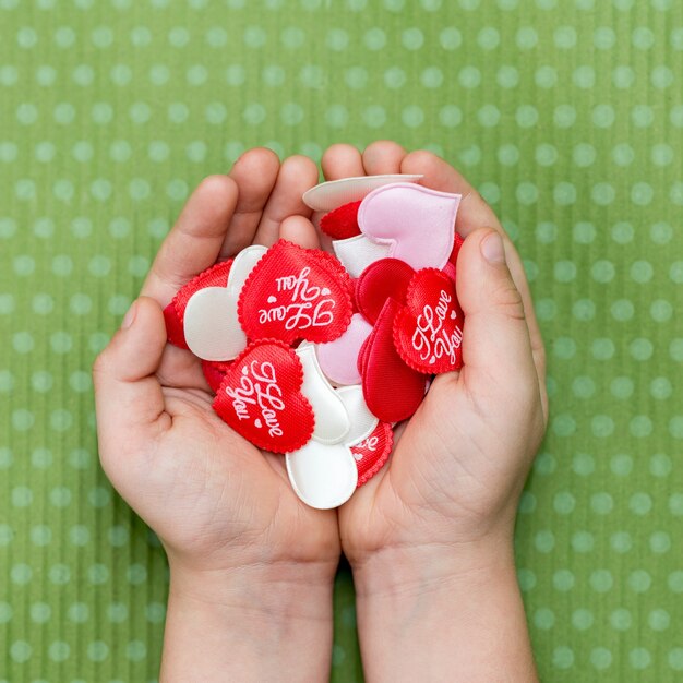 The child holds a red hearts on a green polka dot