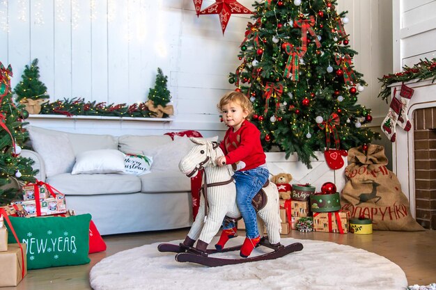 Child on horseback near the Christmas tree Selective focus