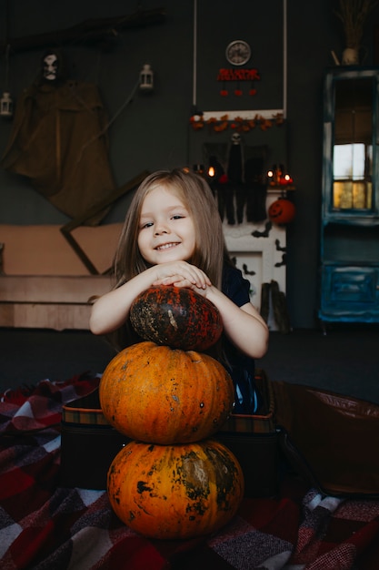 子供がハロウィーンの休日にカボチャのクローズアップを抱擁します。