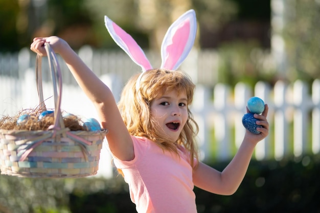 Child hunting easter eggs cute kid in rabbit costume with bunny ears having easter