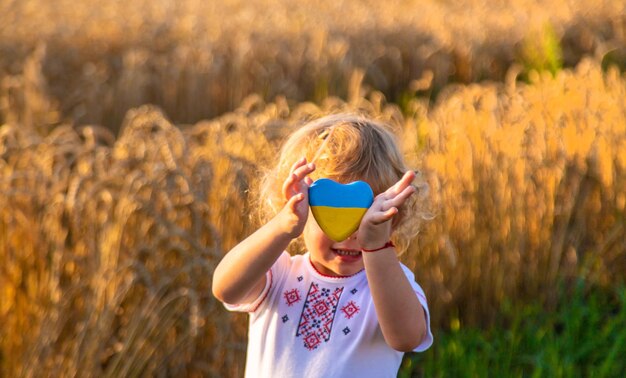 Фото Ребенок в пшеничном поле с флагом украины выборочный фокус природа
