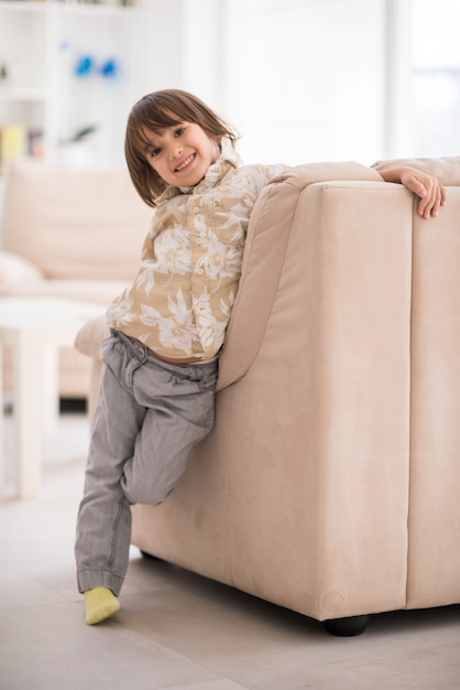 Child inside interior of modern home sitting on sofa