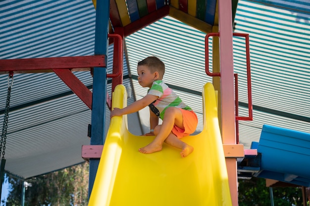 The child is afraid of rolling down the childrens slide