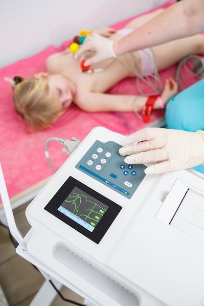 The child is doing an electrocardiogram of the heart, the diagnosis of heart disease in children.