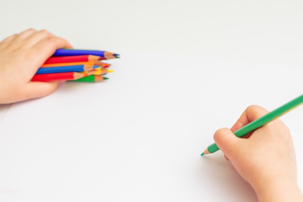 Il bambino sta disegnando con una matita colorata