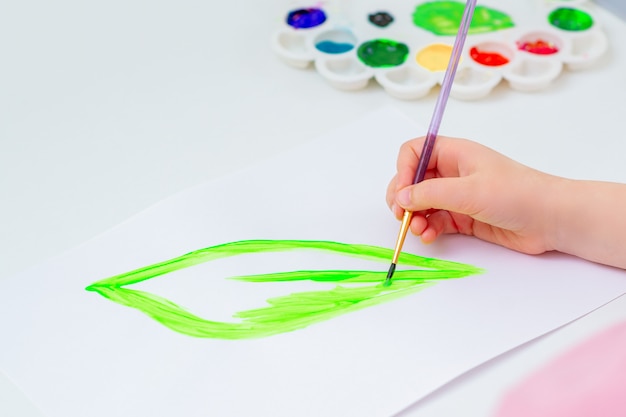 Child is drawing green leaf